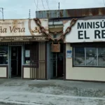 Fachada del local en Cartago con cartel dividido y encadenado, mostrando 'Doña Vera' y 'Minisúper El Resi', simbolizando la persistencia de malas prácticas comerciales.